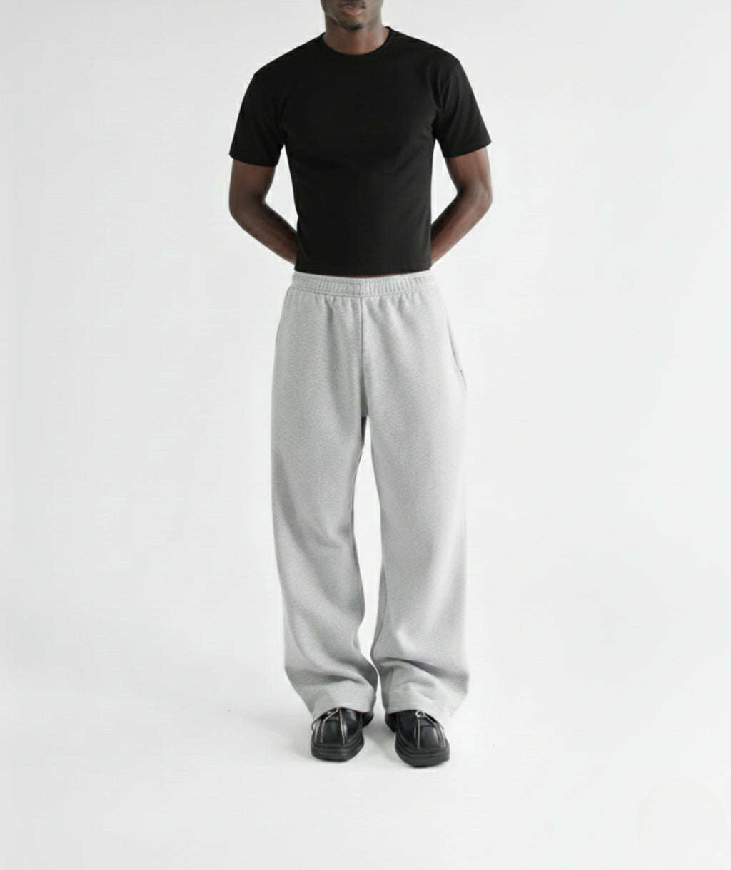 Model standing with hands in pockets, wearing marl gray straight-leg sweatpants with fitted black tshirt to show the relaxed fit and drape